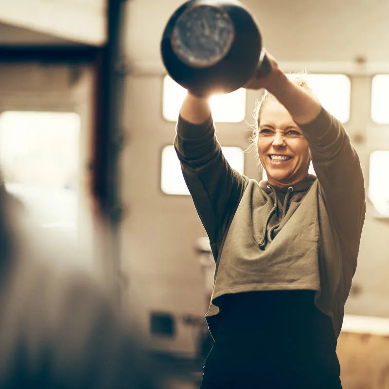 Young woman training with weights at Winslade Park Gym
